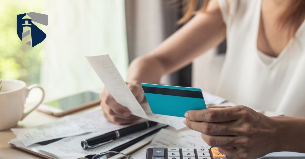 Woman holds credit card in one hand and reviews a bill in the other